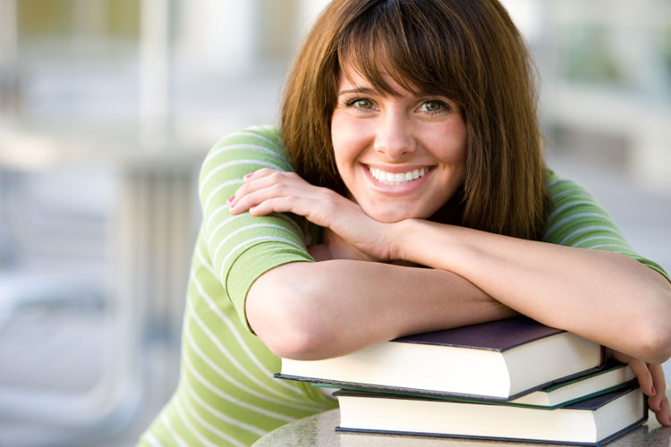 Smiling female leaning on books