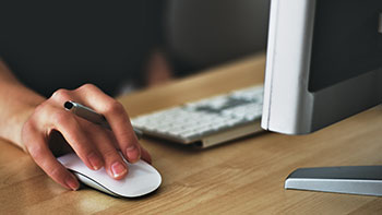 women hand on mouse working at a computer